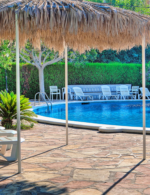Partial view of the pool at Hotel Vista Alegre, surrounded by hedges
