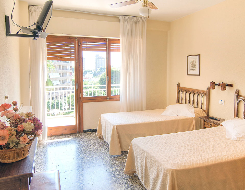 Habitación con camas individuales y balcón con vistas despejadas