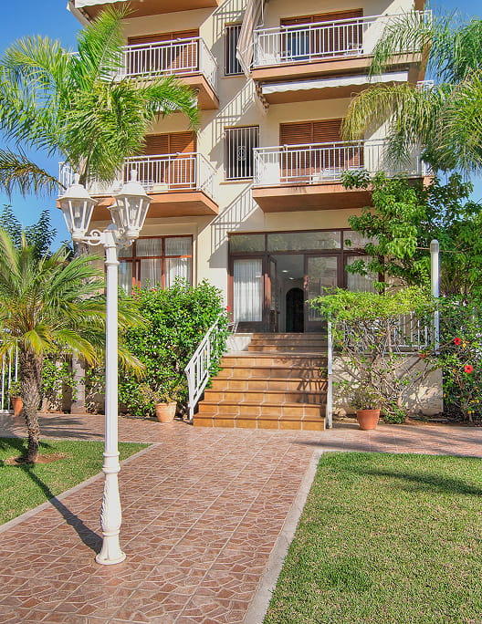 Access to the hotel reception through a garden area.
